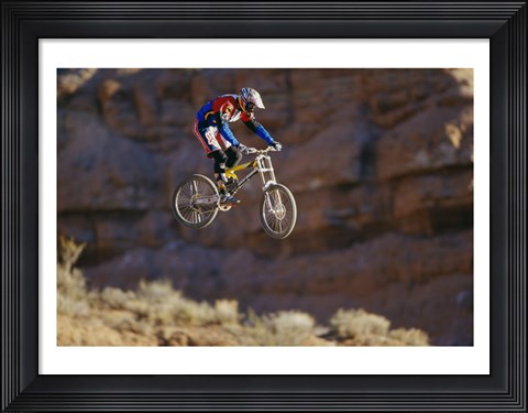 Framed Side profile of a person on a bicycle in mid air Print