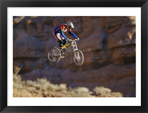 Framed Side profile of a person on a bicycle in mid air Print