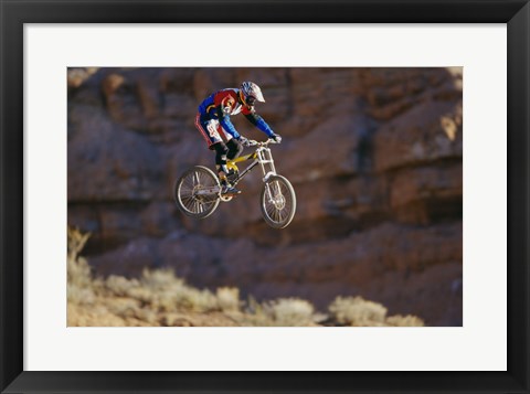 Framed Side profile of a person on a bicycle in mid air Print