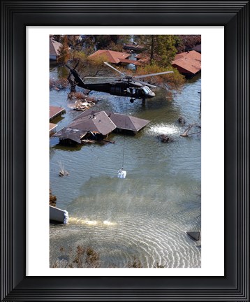Framed Blackhawk helicopter drops sandbags into an area where the levee broke due to Hurricane Katrina Print