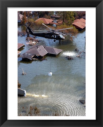 Framed Blackhawk helicopter drops sandbags into an area where the levee broke due to Hurricane Katrina Print