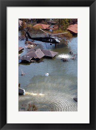 Framed Blackhawk helicopter drops sandbags into an area where the levee broke due to Hurricane Katrina Print