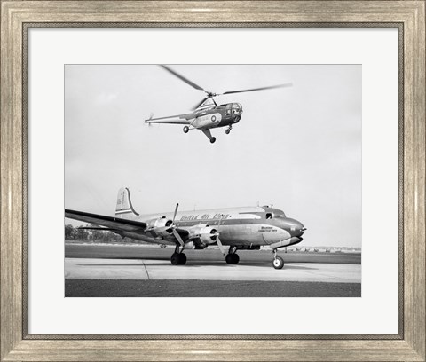 Framed Low angle view of a helicopter in flight and an airplane at an airport, Sikorsky Helicopter, Douglas DC-4 Print