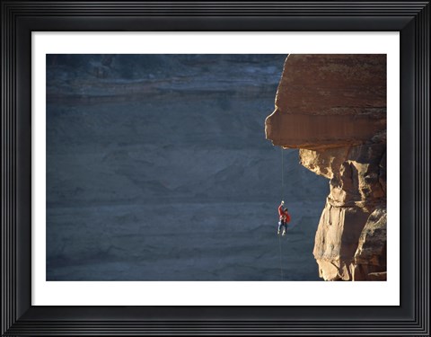 Framed Man hanging from a rope on the edge of a cliff Print