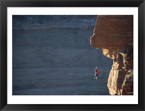 Framed Man hanging from a rope on the edge of a cliff Print