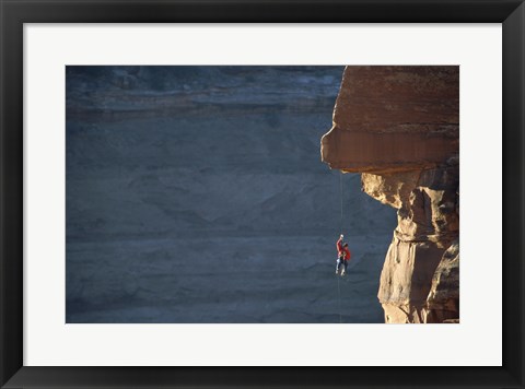 Framed Man hanging from a rope on the edge of a cliff Print