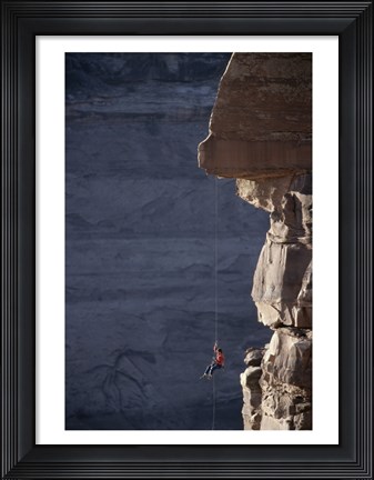 Framed Man hanging from a rope on the edge of a cliff Print