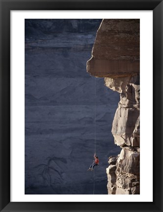 Framed Man hanging from a rope on the edge of a cliff Print