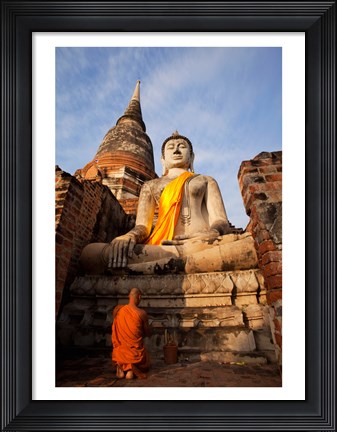 Framed Monk praying in front of a statue of Buddha Print