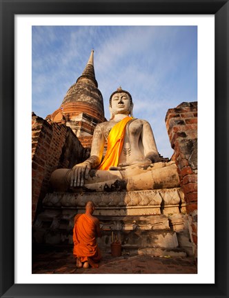 Framed Monk praying in front of a statue of Buddha Print