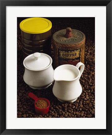 Framed Close-up of a mug of milk with a measuring spoon and jars on coffee beans Print