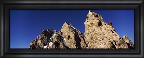 Framed Low angle view of a man climbing up a mountain, Rockchuck Peak, Grand Teton National Park, Wyoming, USA Print