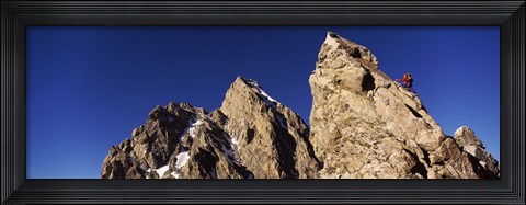 Framed Low angle view of a man climbing up a mountain, Rockchuck Peak, Grand Teton National Park, Wyoming, USA Print
