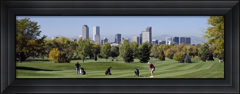 Framed Four people playing golf with buildings in the background, Denver, Colorado, USA Print