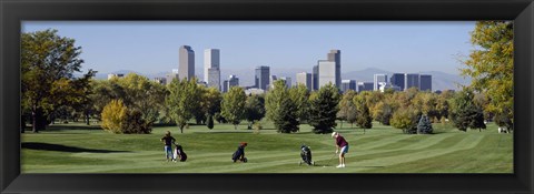 Framed Four people playing golf with buildings in the background, Denver, Colorado, USA Print