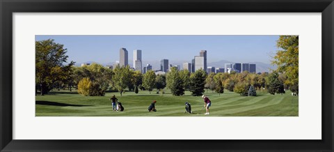 Framed Four people playing golf with buildings in the background, Denver, Colorado, USA Print