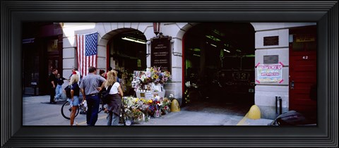 Framed Rear view of three people standing in front of a memorial at a fire station, New York City, New York State, USA Print