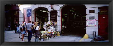 Framed Rear view of three people standing in front of a memorial at a fire station, New York City, New York State, USA Print