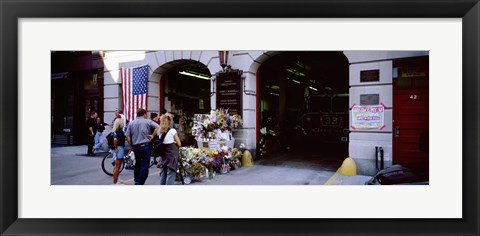 Framed Rear view of three people standing in front of a memorial at a fire station, New York City, New York State, USA Print
