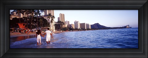 Framed Rear view of a couple wading on the beach, Waikiki Beach, Honolulu, Oahu, Hawaii, USA Print