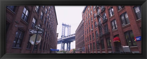 Framed Low angle view of a suspension bridge viewed through buildings, Manhattan Bridge, Brooklyn, New York City, New York State, USA Print