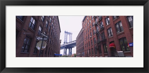 Framed Low angle view of a suspension bridge viewed through buildings, Manhattan Bridge, Brooklyn, New York City, New York State, USA Print