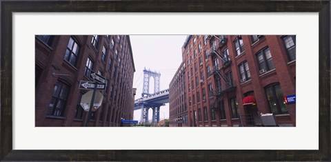 Framed Low angle view of a suspension bridge viewed through buildings, Manhattan Bridge, Brooklyn, New York City, New York State, USA Print