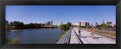 Framed Bicyclists along the Sacramento River with Tower Bridge in background, Sacramento, Sacramento County, California, USA Print