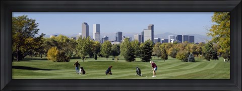 Framed Four people playing golf with buildings in the background, Denver, Colorado, USA Print
