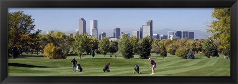 Framed Four people playing golf with buildings in the background, Denver, Colorado, USA Print