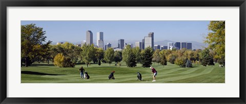 Framed Four people playing golf with buildings in the background, Denver, Colorado, USA Print