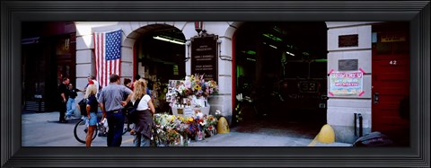 Framed Rear view of three people standing in front of a memorial at a fire station, New York City, New York State, USA Print