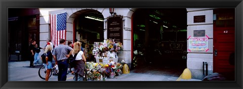 Framed Rear view of three people standing in front of a memorial at a fire station, New York City, New York State, USA Print