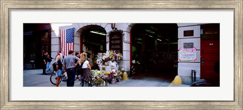 Framed Rear view of three people standing in front of a memorial at a fire station, New York City, New York State, USA Print