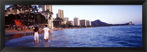 Framed Rear view of a couple wading on the beach, Waikiki Beach, Honolulu, Oahu, Hawaii, USA Print
