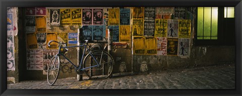 Framed Bicycle leaning against a wall with posters in an alley, Post Alley, Seattle, Washington State, USA Print