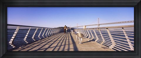 Framed Couple walking on a pier, Bay Bridge, San Francisco, California, USA Print