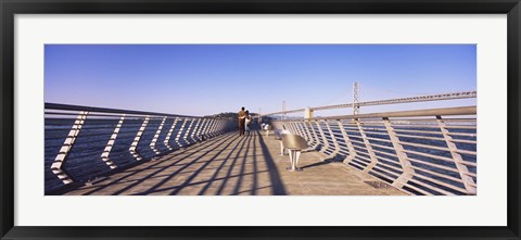Framed Couple walking on a pier, Bay Bridge, San Francisco, California, USA Print