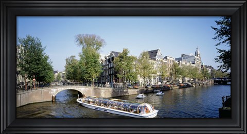 Framed Netherlands, Amsterdam, tour boat in channel Print