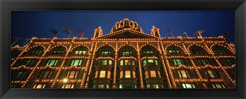 Framed Low angle view of a building lit up at night, Harrods, London, England Print