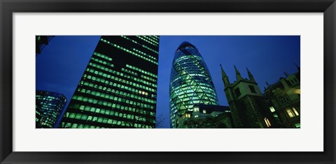 Framed Low angle view of buildings lit up at night, Sir Norman Foster Building, Swiss Re Tower, London, England Print