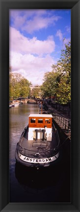 Framed Tourboat docked in a channel, Amsterdam, Netherlands Print