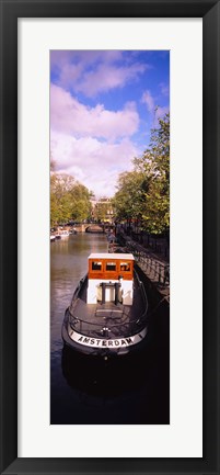 Framed Tourboat docked in a channel, Amsterdam, Netherlands Print