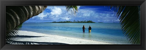 Framed Rear view of two native teenage girls in lagoon, framed by palm tree, Aitutaki, Cook Islands. Print