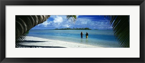 Framed Rear view of two native teenage girls in lagoon, framed by palm tree, Aitutaki, Cook Islands. Print