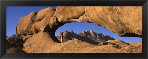 Framed Mountains viewed through a natural arch with a mother holding her baby, Spitzkoppe, Namib Desert, Namibia Print