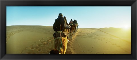 Framed Row of people riding camels through the desert, Sahara Desert, Morocco Print