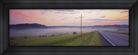 Framed Country road and telephone lines splitting farmlands at dawn, Finland Print