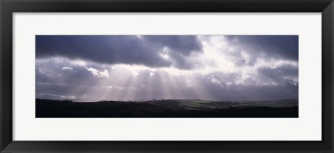 Framed Sunbeams radiating through dark clouds over rolling hills, Dartmoor, Devon, England Print