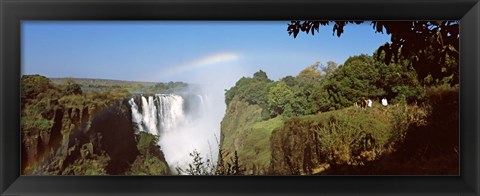 Framed Tourists at a viewing point looking at the rainbow formed over Victoria Falls, Zimbabwe Print